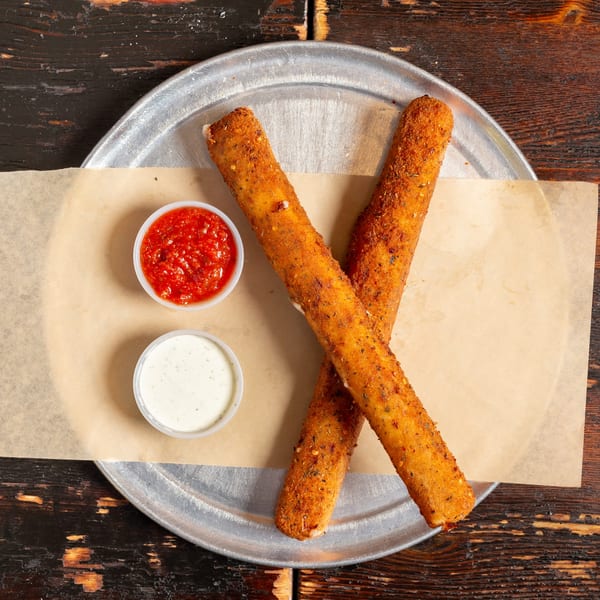 Two Bambino's Urban Pizzeria mozzarella sticks with marinara and ranch dipping sauces.